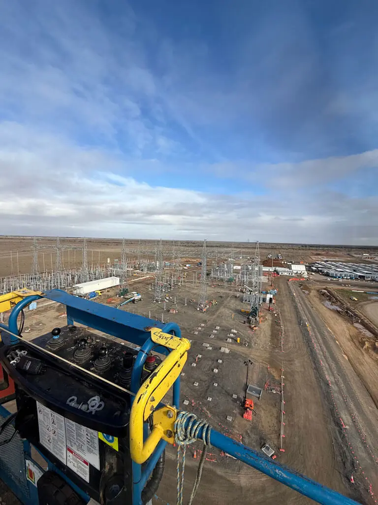 View from a high lift overlooking a large electrical substation under construction, with steel structures and vehicles across a dirt lot—an ideal project for ecological consultants Australia to help balance development and environmental care.